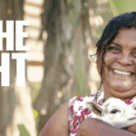 Smiling woman holding lamb